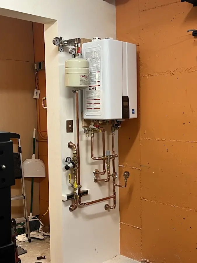 Plumbing technician inspecting water heater connections in Fort Irwin